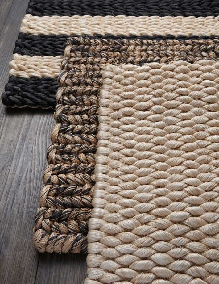 Tapis en fibres naturelles tressées, bordure foncée, posé sur un parquet