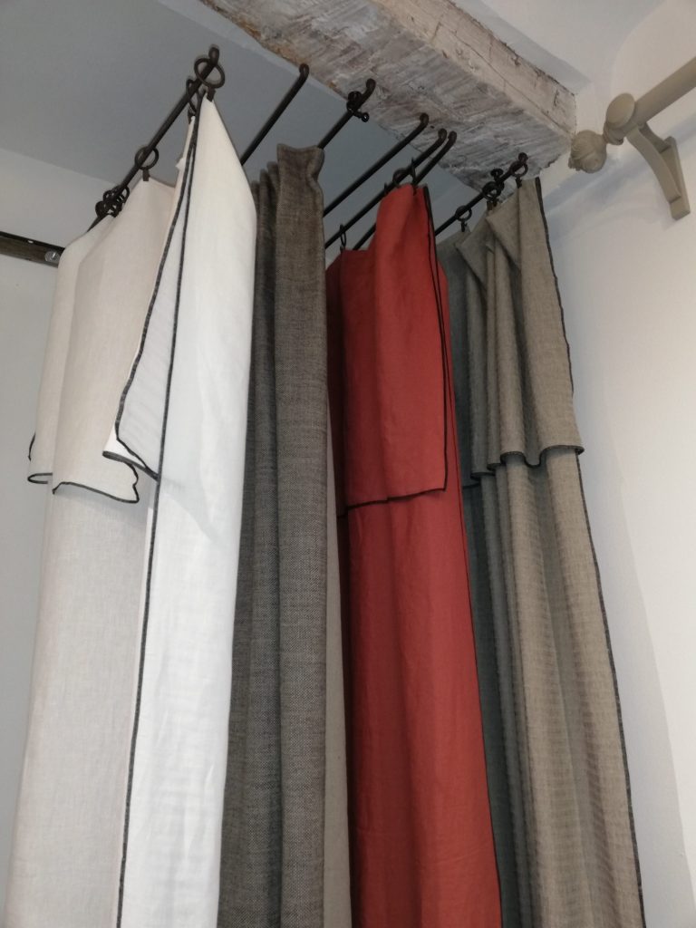 Rideaux prêts à poser en lin blanc, gris et terracotta suspendus à une tringle en fer