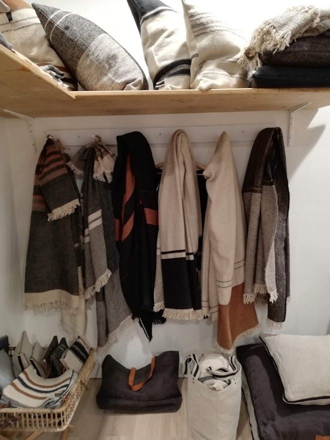 Plaids et jetés de lit en lin et laine pliés sur une étagère