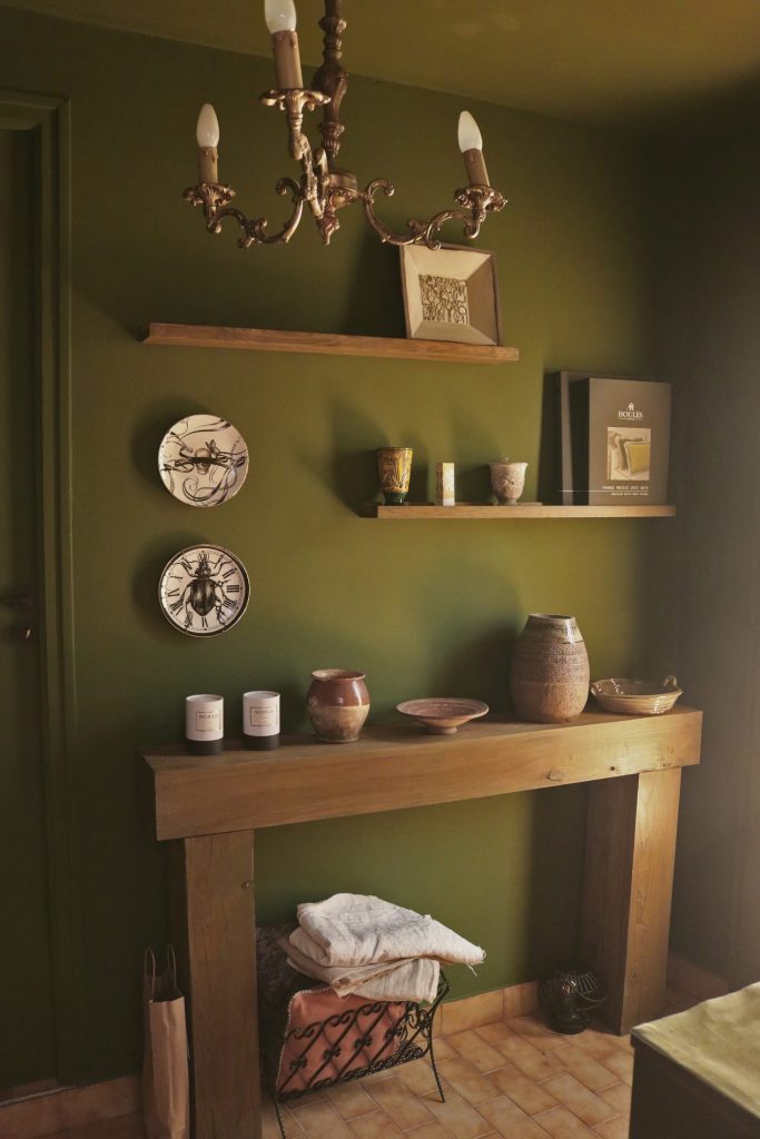 Coin décoration du showroom de Cucuron, mur olive, console en bois et céramiques