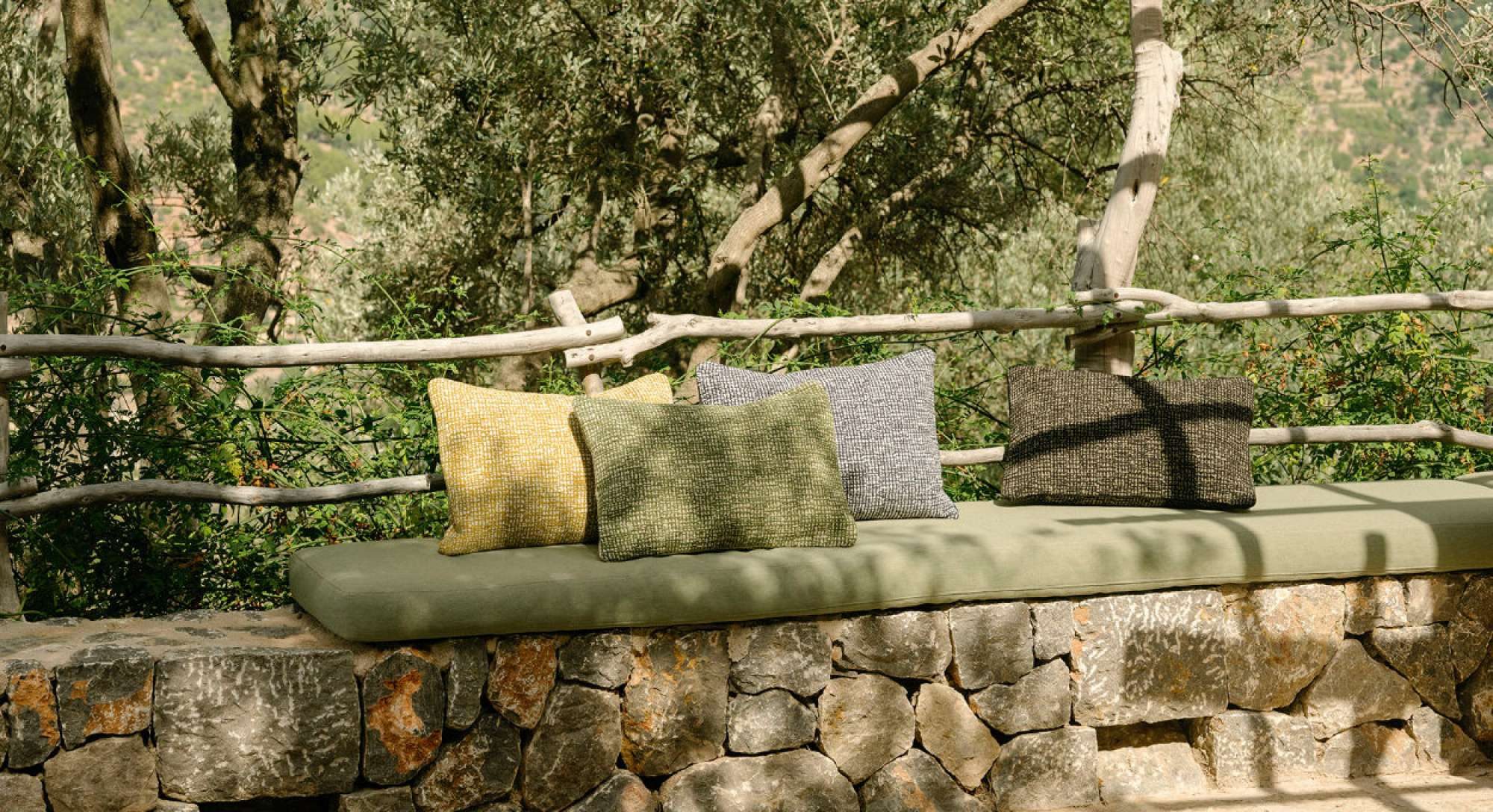 Banquette d'extérieur en pierre sèche et coussins en tissu outdoor